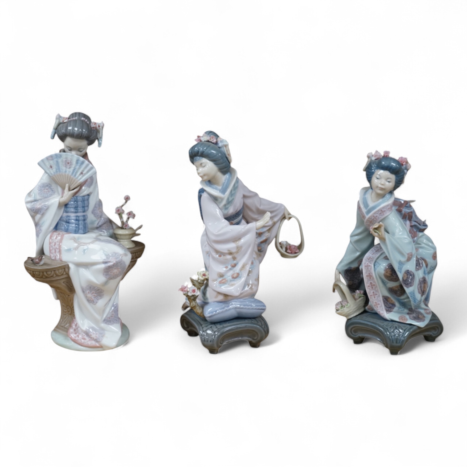 Three Lladro models of seated Geisha. Tallest 23cm